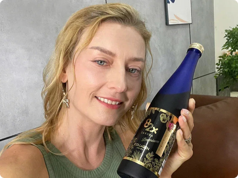 Woman holding a bottle of 82X Sakura Premium Collagen beauty supplement.